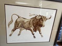 Close-up of sepia bull print showing artwork, mat, frame, and signature