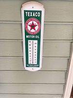 Full view of Texaco wall thermometer mounted on siding