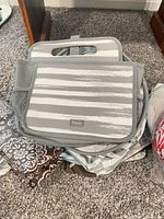 Gray striped insulated bag atop other bags