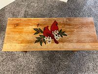 Top view of wooden bench showing cardinal painting and surface wear