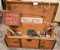 open wood steamer trunk with assorted decor visible