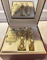 Watch and bracelet set displayed in wooden box with tags visible