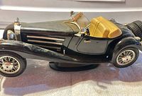 Left side view of Bburago 1936 Mercedes-Benz 500K model showing black body, tan interior, wire wheels, rear spare