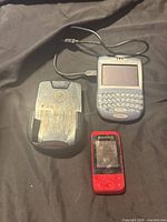 Overview of all three items: BlackBerry 7290, charging dock, Riptunes player