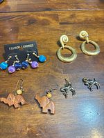 All six pairs of earrings displayed on wooden surface