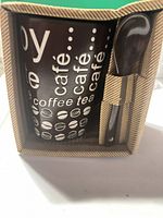 Boxed set front showing mug graphics and spoon in handle slot