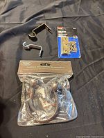 All items laid out: hinge pack, holdback set, two curtain brackets