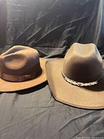 Overview of both hats side by side on black backdrop
