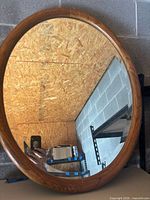 Front view of round oak-framed mirror