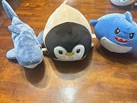 Front view of all three plush toys on table