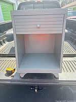 Front view showing shutter-front drawer, open cubby, arched base