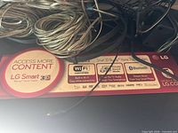 Top view of LG BH6730 unit showing Smart 3D branding card and bundled speaker wires