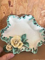 Top view showing cream dish with green rim and yellow rose appliqués