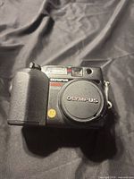 Front view showing Olympus branding, lens cap, 4.1 MP badge