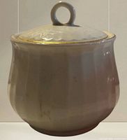 Front view of fluted sugar bowl with lid showing gold-trimmed rim and handle