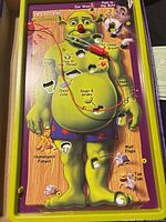 Full game board with Shrek artwork, tweezers wired to buzzer, visible cavities