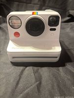 Front view showing lens, flash, controls and Polaroid Now branding