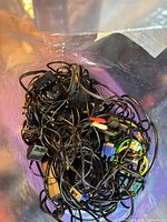 Pile of assorted black cables inside plastic bag