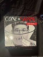 Closed box front displaying Cone of Shame branding and age rating 16+