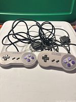 Both SNES wired controllers with cords visible