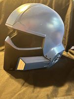 Left-front view of blue 3D-printed helmet showing black jaw section and open visor area