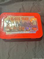 Front view of red tin showing Classic Train label through protective film