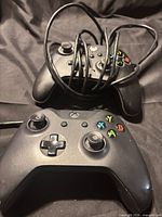 Two black Xbox One controllers with tangled micro-USB cables