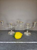 Both candelabras side by side with lemon and ruler for scale