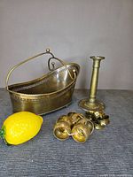 Group view showing brass wine cradle, candlestick, nine napkin rings