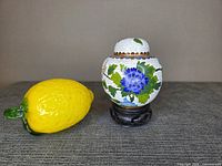 Jar and stand beside lemon for scale, full front view