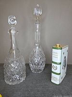 Two clear decanters and porcelain Camus Napoleon bottle side by side