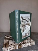 Front and spine of green cloth book standing in slipcase