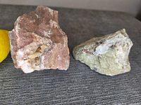 Two mineral specimens beside lemon for scale