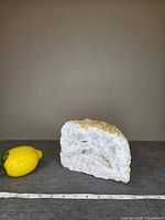 Geode standing beside lemon and ruler showing overall size