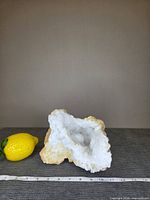 Front view of quartz geode beside lemon and ruler