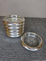 Stack of six coasters with one separated showing rim and glass base