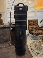 Full front view of black SKB hard plastic golf travel case standing upright