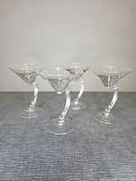 Four martini glasses standing upright on fabric surface
