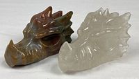 Two crystal dragon head carvings side by side