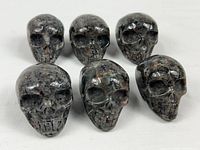 front view of all six carved stone skull figurines