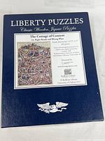 Front of navy Liberty Puzzles box with title sheet