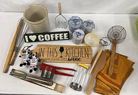 Full lot overhead showing crock, signs, utensils, enamel cups, Fire King bowl, plush cows, towels