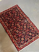 Full view of antique Persian rug showing overall design and borders