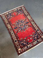 Full view of red Persian rug showing overall design and size