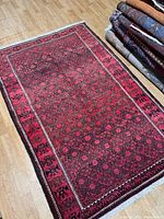 Full view of rug on floor showing overall design and borders