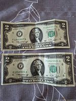 Obverse of both $2 notes showing serials and seal