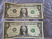 Obverse of both $1 notes showing serial numbers and series years