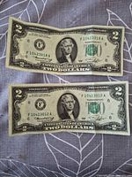Obverse of both $2 notes showing serial numbers and condition