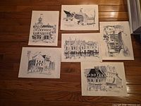 All six black-and-white prints laid out on hardwood floor