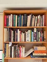 Full bookcase showing most of the books in the lot